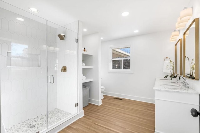 bathroom with walk in shower, vanity, toilet, and hardwood / wood-style floors