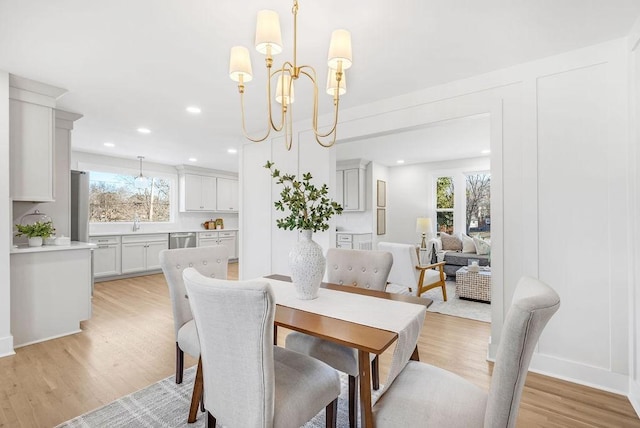 dining space with an inviting chandelier and light wood-type flooring