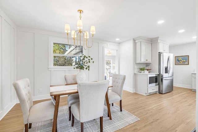 dining area featuring a notable chandelier and light hardwood / wood-style floors