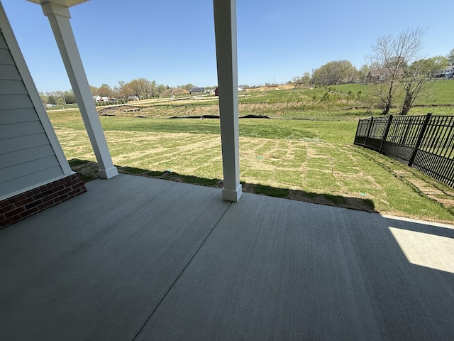 view of patio featuring a rural view and fence
