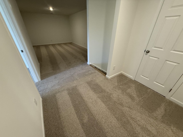 hallway featuring baseboards and carpet flooring