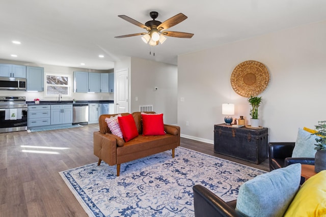 living area with recessed lighting, visible vents, a ceiling fan, wood finished floors, and baseboards