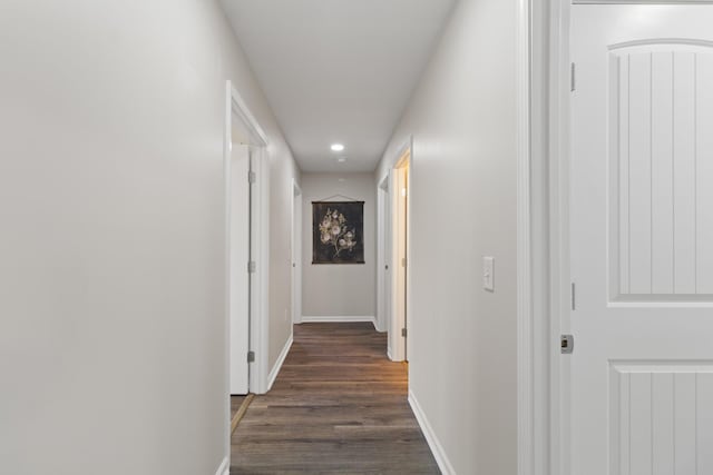 hall with dark wood-style floors and baseboards