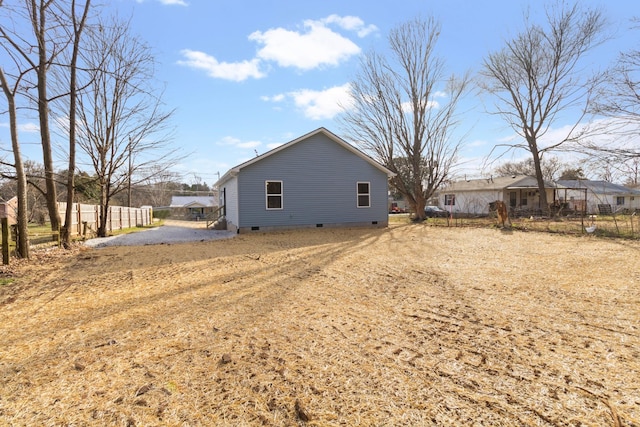 view of side of property featuring a residential view, crawl space, and fence