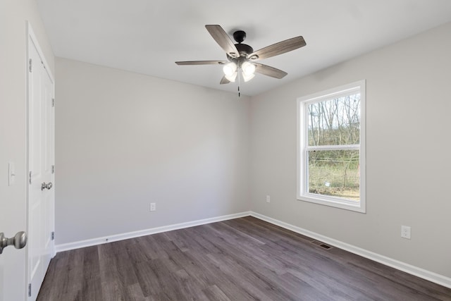 spare room featuring dark wood-style floors, baseboards, and a ceiling fan