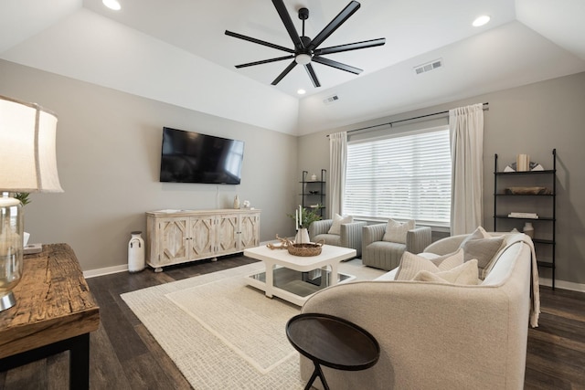 living room with a raised ceiling, vaulted ceiling, and dark hardwood / wood-style flooring