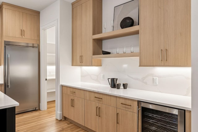 kitchen featuring light brown cabinetry, tasteful backsplash, beverage cooler, and built in fridge