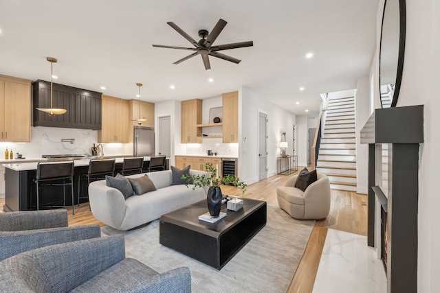 living room featuring ceiling fan, wine cooler, and light wood-type flooring