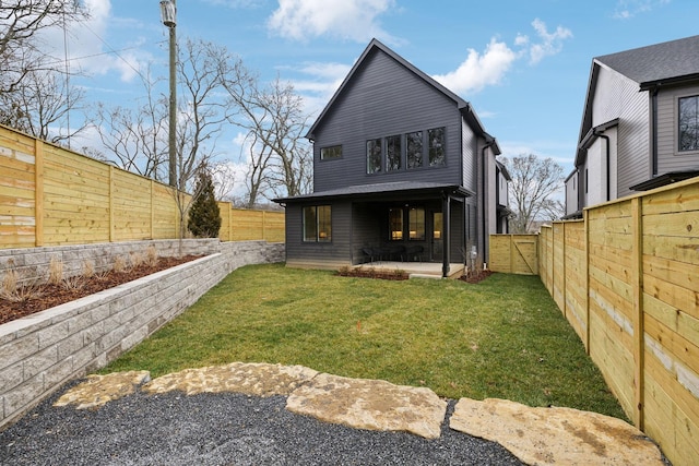 rear view of house featuring a yard and a patio