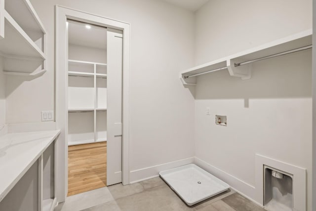 clothes washing area featuring washer hookup and light hardwood / wood-style flooring