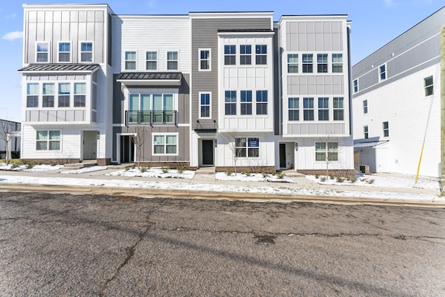 townhome / multi-family property with metal roof, board and batten siding, and a standing seam roof