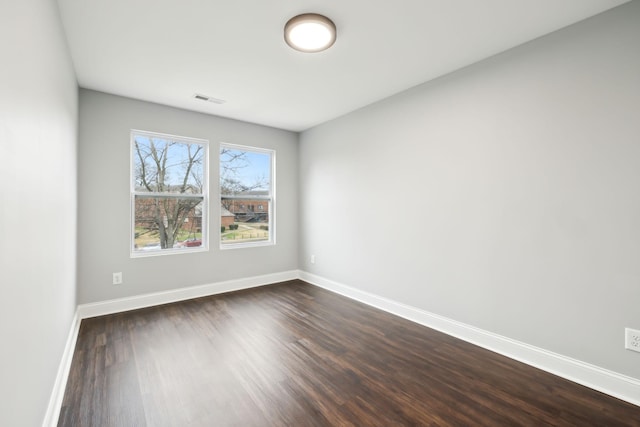 unfurnished room with dark hardwood / wood-style flooring