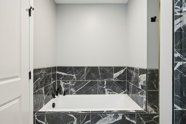 bathroom featuring tiled tub