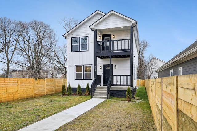 view of front of home featuring a balcony and a front yard