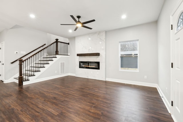 unfurnished living room with ceiling fan, a high end fireplace, and dark hardwood / wood-style floors