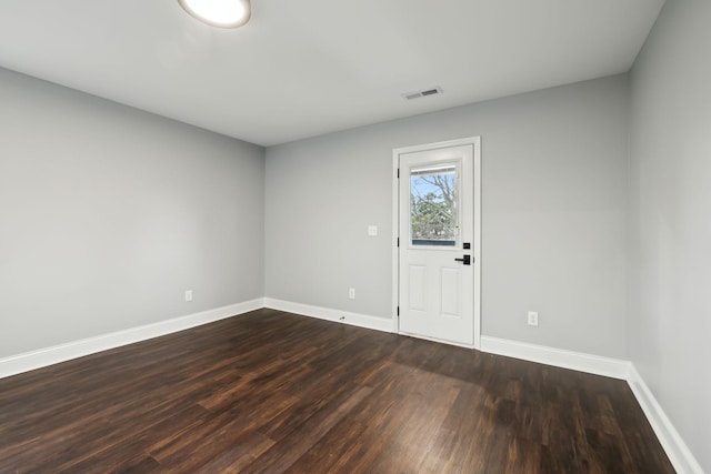 empty room with dark hardwood / wood-style flooring