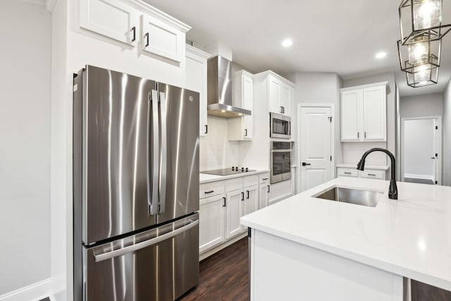 kitchen with white cabinetry, appliances with stainless steel finishes, sink, and wall chimney range hood