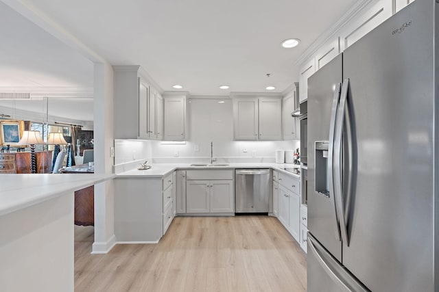 kitchen with white cabinetry, appliances with stainless steel finishes, sink, and light hardwood / wood-style flooring