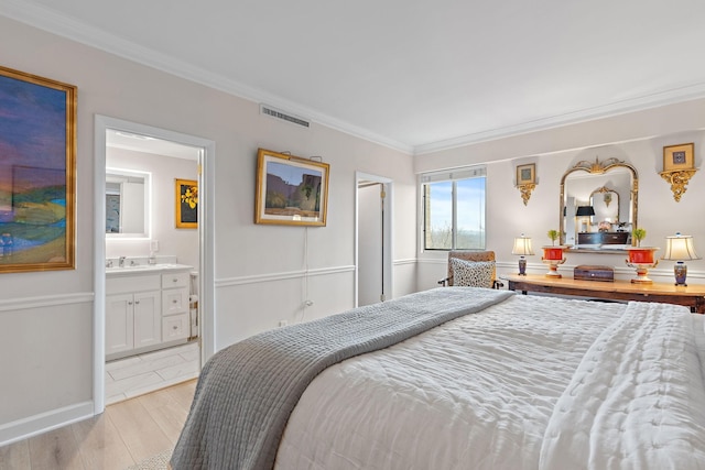 bedroom with crown molding, connected bathroom, and light hardwood / wood-style flooring