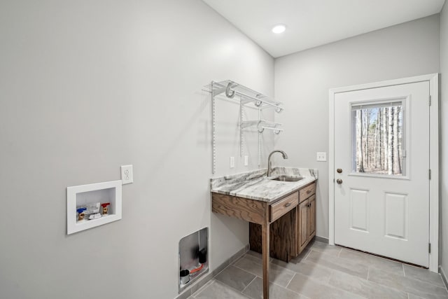 washroom featuring washer hookup, sink, and light tile patterned floors