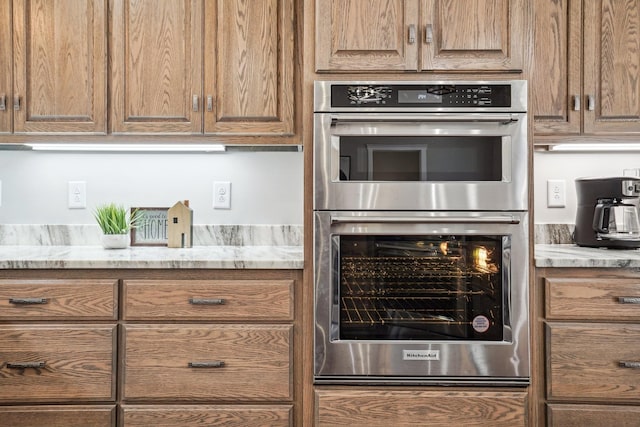 kitchen featuring light stone counters and double oven