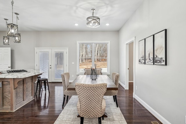 dining space with french doors, dark hardwood / wood-style floors, and a notable chandelier