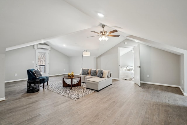 living room featuring lofted ceiling, wood-type flooring, and a wall unit AC