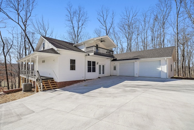 view of front facade with ceiling fan, a porch, cooling unit, a garage, and a balcony