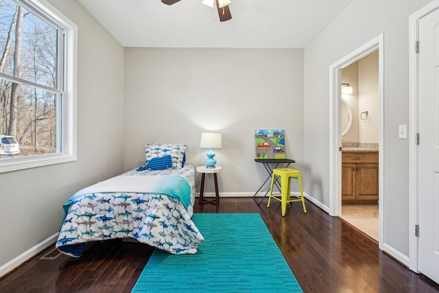 bedroom with multiple windows, ensuite bath, dark hardwood / wood-style floors, and ceiling fan