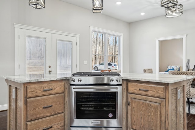 kitchen with pendant lighting, dark wood-type flooring, stainless steel gas range, and a center island