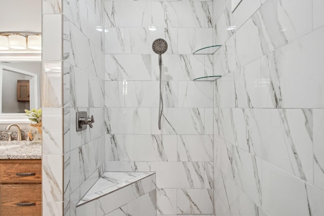 bathroom with vanity and a tile shower