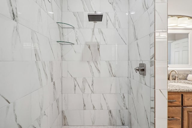 bathroom with vanity and a tile shower