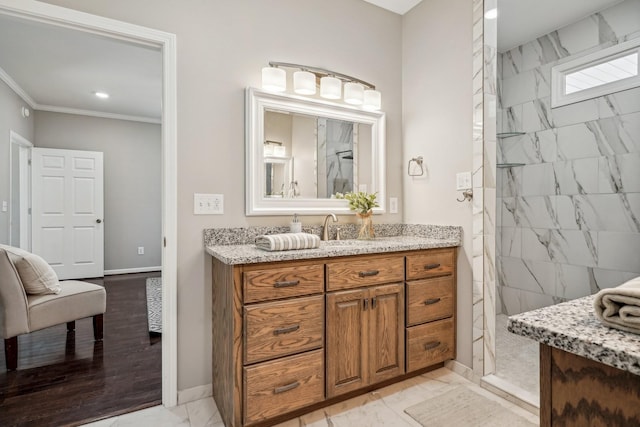 bathroom with vanity, ornamental molding, and a tile shower