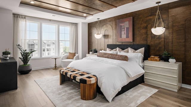 bedroom featuring a raised ceiling and hardwood / wood-style flooring