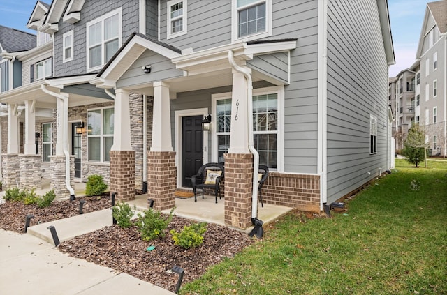 property entrance featuring a porch and a lawn