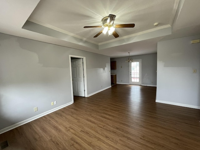 unfurnished room featuring crown molding, a tray ceiling, dark hardwood / wood-style flooring, and ceiling fan with notable chandelier