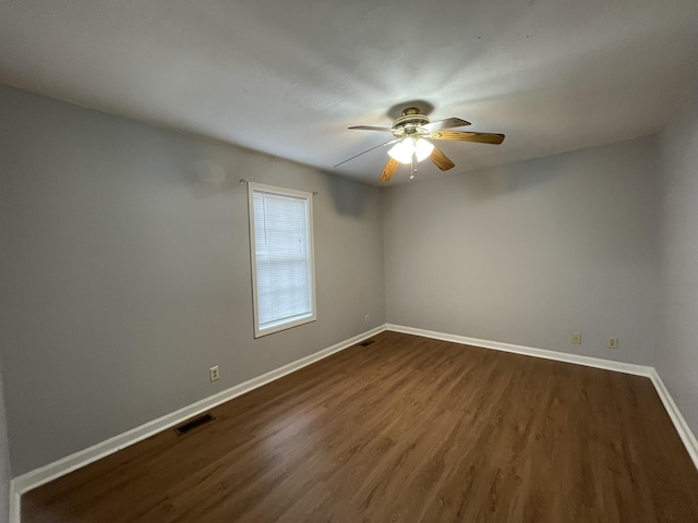 empty room featuring dark wood-type flooring and ceiling fan