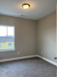 empty room with dark colored carpet