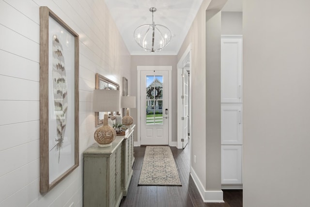 doorway to outside with dark hardwood / wood-style flooring and a notable chandelier