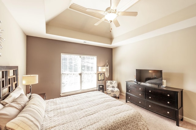 bedroom featuring a tray ceiling, ceiling fan, and light carpet