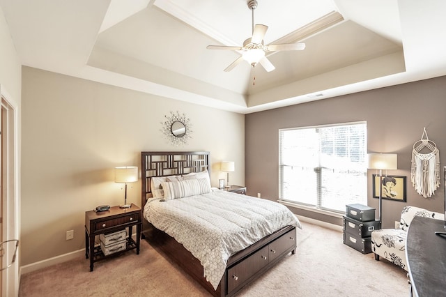 carpeted bedroom with a tray ceiling and ceiling fan