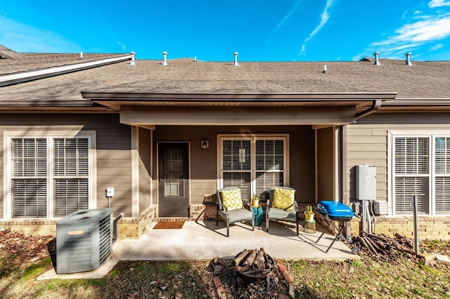 rear view of property with a patio area, cooling unit, and an outdoor fire pit