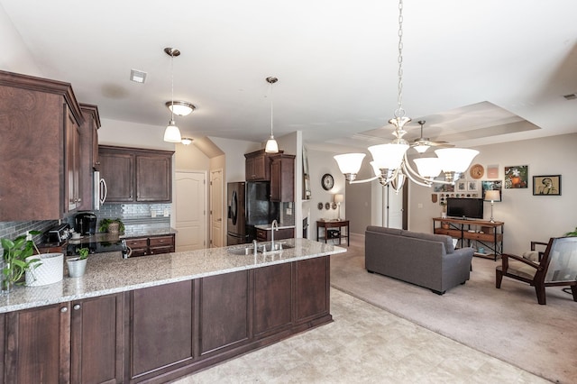 kitchen featuring sink, kitchen peninsula, hanging light fixtures, and dark brown cabinetry