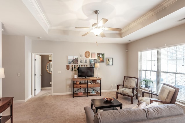 living room featuring a tray ceiling, light carpet, crown molding, and ceiling fan