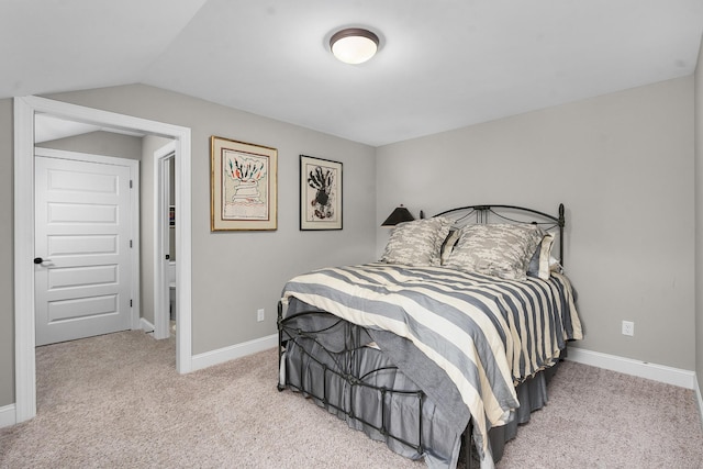 bedroom with light colored carpet and vaulted ceiling