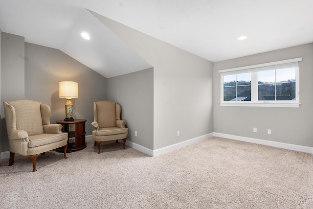 living area featuring vaulted ceiling and carpet