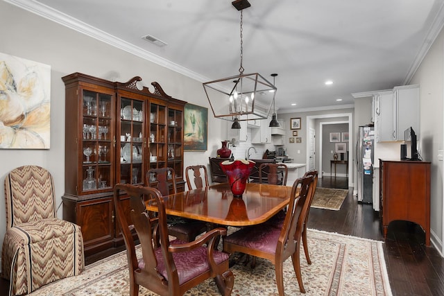 dining room featuring sink, ornamental molding, and dark hardwood / wood-style floors