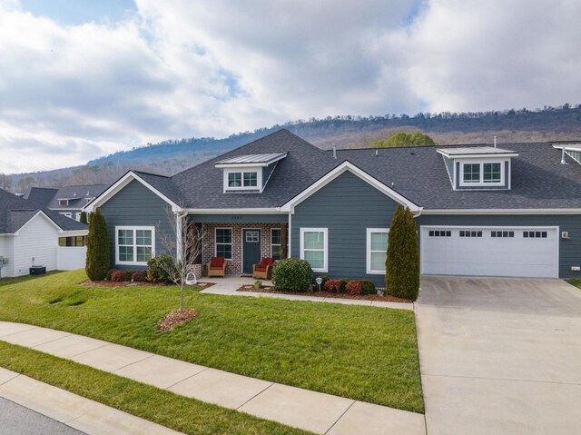 craftsman inspired home featuring a mountain view, a garage, a front yard, and central air condition unit