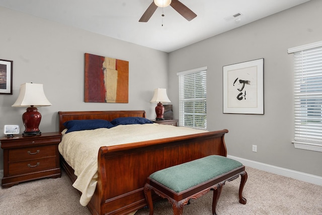 bedroom with multiple windows, light colored carpet, and ceiling fan