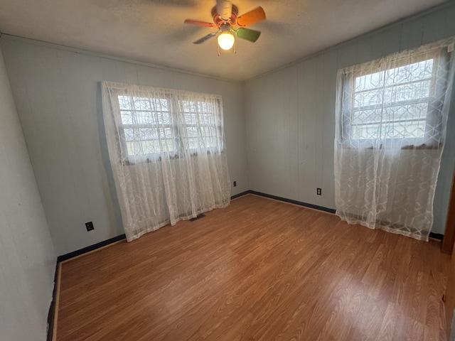 unfurnished room featuring a textured ceiling, wood-type flooring, ceiling fan, and plenty of natural light